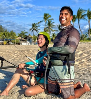 mulher jovem tendo aula de kitesurf ao lado o seu instrutor