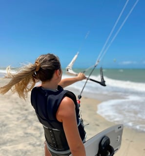 Mulher fazendo kitesurf na praia