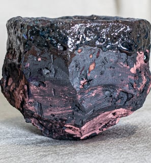 Yunomi cup made in Amman, Jordan, with rugged textures, charcoal body, and fire-kissed rose accents