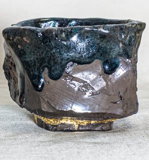 Vessel made in Amman, Jordan with dark glaze, molten textures, and Kintsugi repair using 24K gold