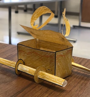 a paper model of the Ark of the Covenant on a desk in a classroom