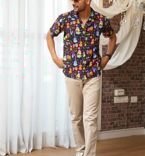 a man in a colorful shirt and tan pants