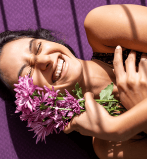 Chica sonriente y feliz con flores violetas