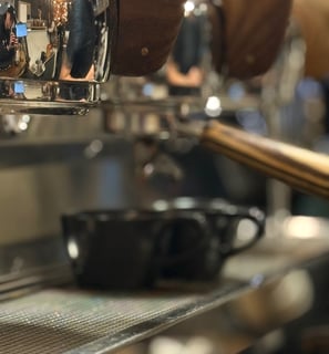 two cups under a portafilter on the drip tray