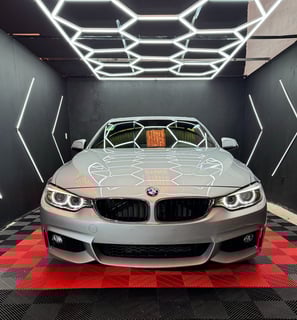 a car in a garage with a car in the background