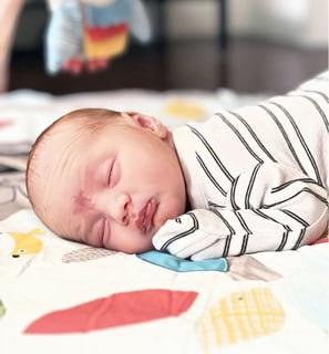 a baby sleeping on a blanket
