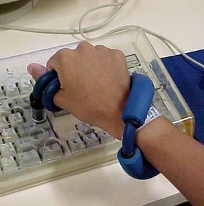 a mão de uma pessoa segurando uma tesoura e um mouse de computador