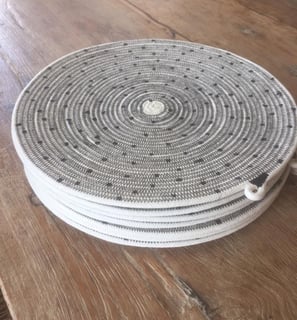 a round wicker basket weave basket with a white and black basket