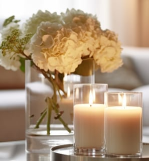 <img src="decoração mesa de centro com vela, bandeja espelhada, vaso de vidro e arranjo de flores'".