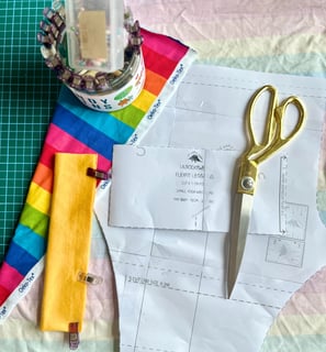 a pair of scissors with fabric and a lilrockywear sewing pattern