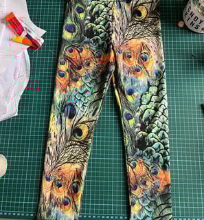 a pair of leggings with a peacock print