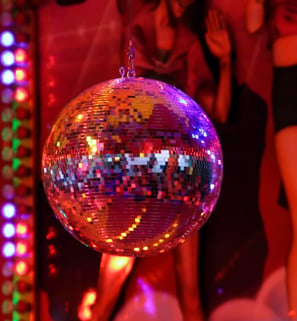 a photograph of a disco ball in front of an image of people dancing.