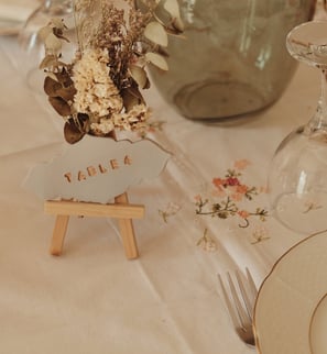 Numéro de table en argile sur chevalet avec fleurs séchées 
