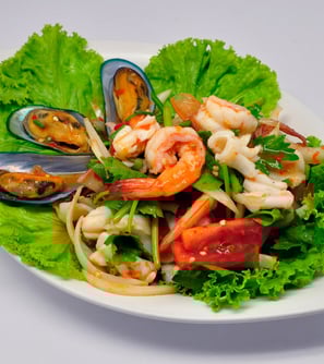 Spicy mixed seafood salad on white plate