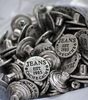 Metal buttons, zipper pulls, and clothing hardware with custom branding