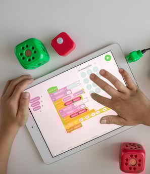 a child's hands on a tablet with dice