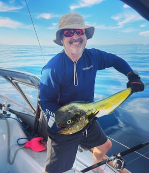 a man holding a fish on a boat