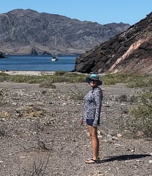 a woman standing in a desert area with mountains in the background