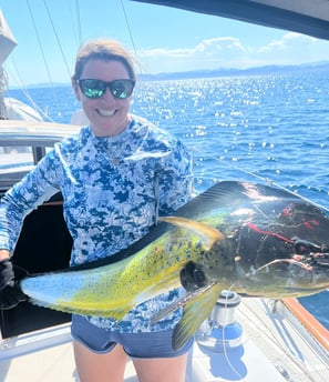 a woman holding a fish fish on a boat