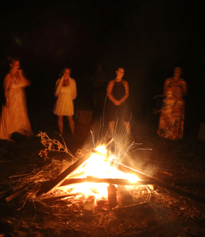 a bunch of people around a fire