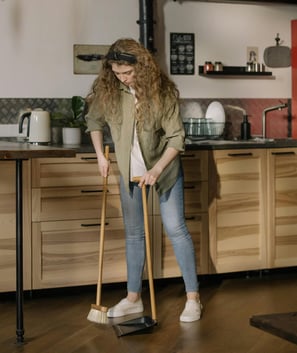 woman sweeping kitchen floor