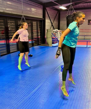 Séance de fitness : deux femmes réalisent un exercice combinant renforcement musculaire et cardio