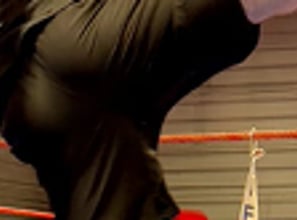 Entraînement de boxe : un boxeur en pleine frappe sur une patte d’ours tenue par son coach