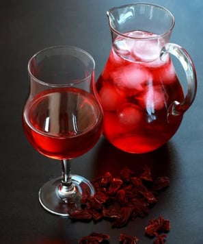 a pitcher of red wine with ice and a glass of wine