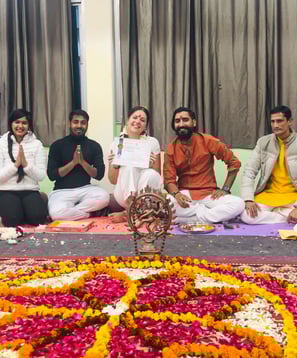 Eva standing with her yoga teachers during the diploma ceremony in Rishikesh, all smiling and celebrating the completion of t