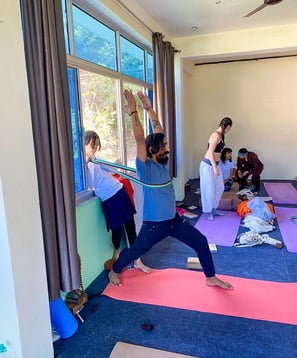 Yoga teacher leading a training class, guiding students through poses and techniques in a focused learning environment.