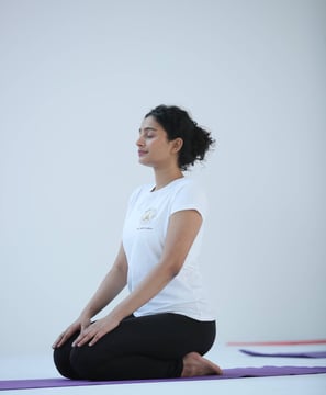 an image of a girl doing yoga with white tshirt and black pant of hathavidya 