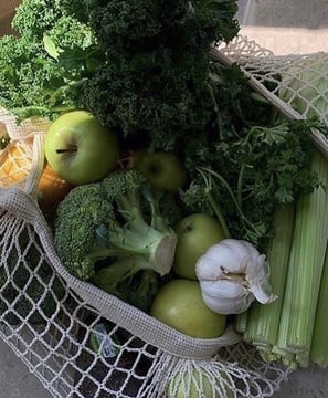 Assortment of fruits and vegetables: garlic, parsley, kale, and apple
