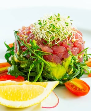 a tuna salad with a lemon wedged in the center