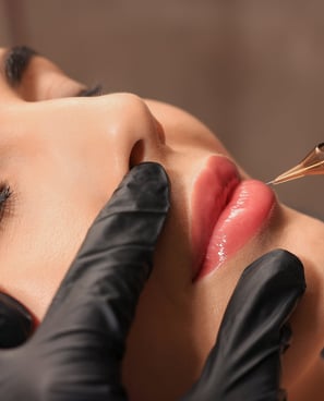 Eine Frau, die ihre Lippen von einer professionellen Kosmetikerin mit Permanent Make-up 