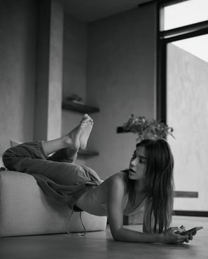 A woman relaxes on a couch with feet up, captured at Casa Wabii by Theodorous Yuvens.