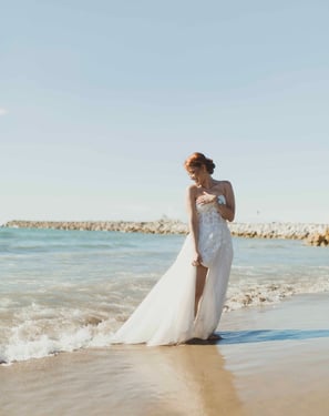 Novia en su vestido, caminando en la playa