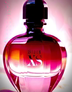 a black xs xs perfume bottle with a pink background