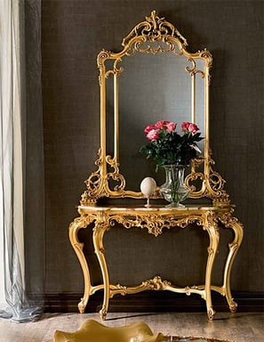 a console table with a mirror and a vase with flowers