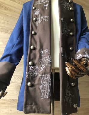 Veste de pirate dont l'histoire est raconté en broderies sur les revers de sa tenue