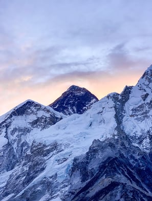 Sunrise over Mount Everest with warm golden light illuminating the peak.