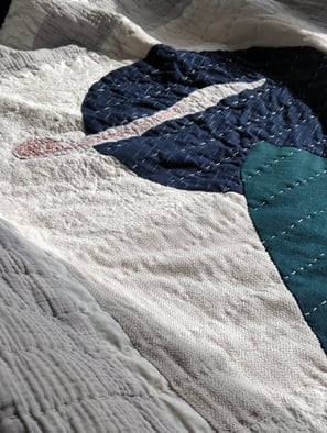 scrap fabric used to make a quilt, using applique and hand stitching.