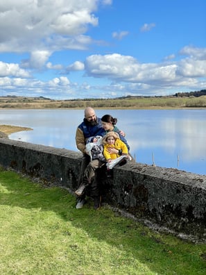 a family of four sitting on a stone wall