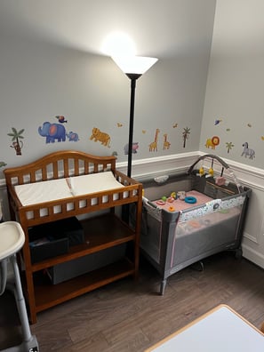 Photo of daycare room. Changing table and infant bed.