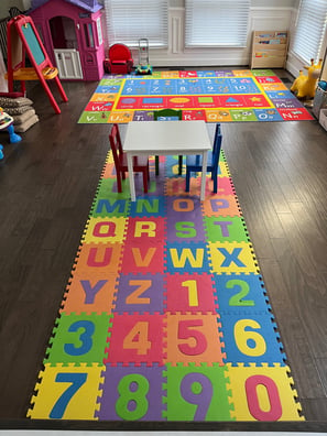 Photo of daycare room where children play. Table of soft mats.