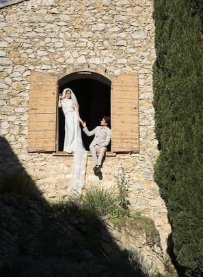 mariée et marié debout devant un bâtiment en pierre rustique, moment intime