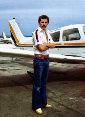 Peter Pickering stands in front of a Piper Cherokee in which he learnt to fly