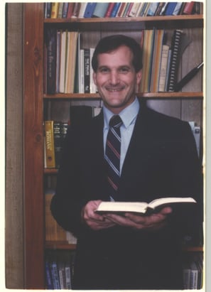 a man in a suit and tie is holding a book
