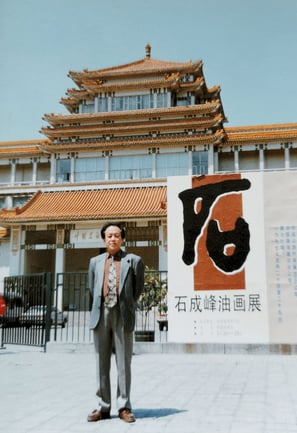 a man in a suit and tie standing in front of a building