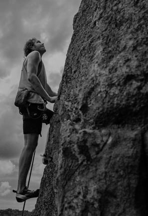 Man Rock Climbing in Black and White