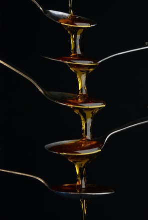 Molasses trickling down teaspoons